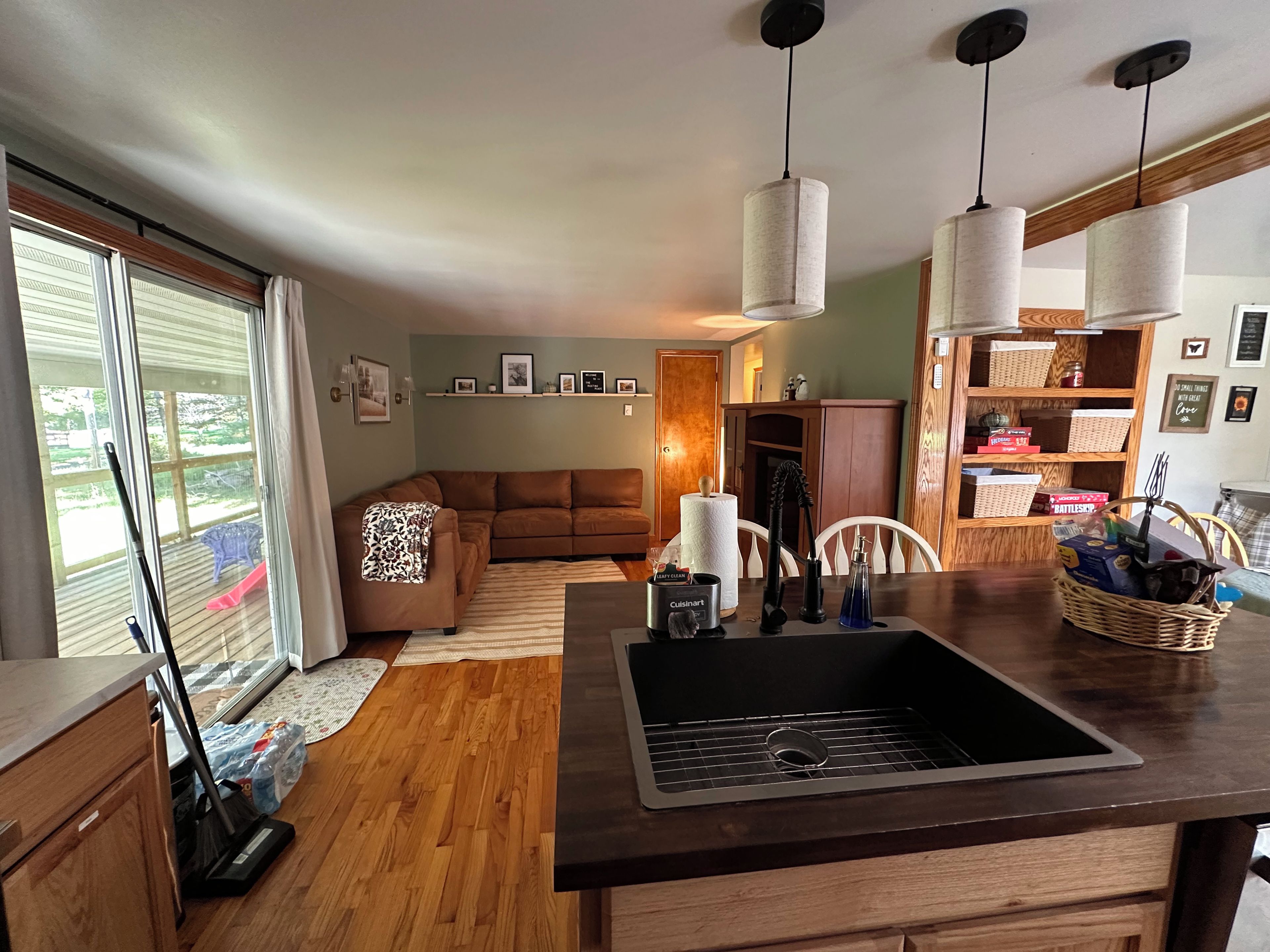 A kitchen with a wooden countertop, a sink, and a dining area with a table and chairs.