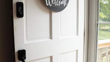 A white door with a 'Welcome' sign and a doorbell.
