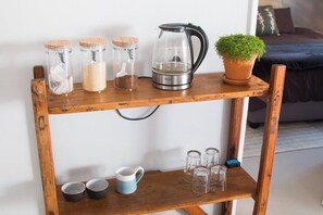 A wooden shelf with jars, a kettle, and a potted plant. - Spacious, Modern Cottage between Mountains and Sea (Cape Town)