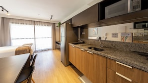 Una cocina moderna con encimera de granito, electrodomésticos de acero inoxidable y muebles de madera.