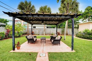 A covered patio area with outdoor furniture, a pergola, and a view of a residential neighborhood. - Tropical 1 Bed 1 Bath Apt Minutes to the Sea, Pool (Lauderdale-by-the-Sea)