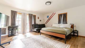 Ein Schlafzimmer mit einem Bett, einem Schreibtisch, einem Stuhl und einem Skiständer.