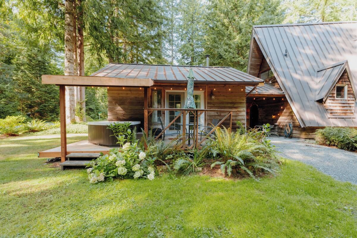 A rustic cabin with a wooden exterior, a covered porch, and a small garden area.