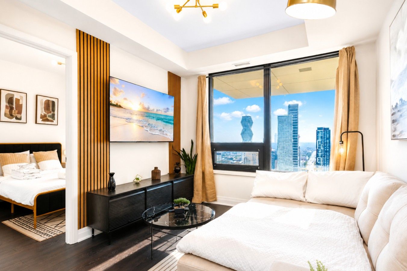 Une chambre d’hôtel moderne équipée d’un lit, d’un canapé, d’une télévision et offrant une vue sur la ville, ainsi qu’une grande fenêtre.