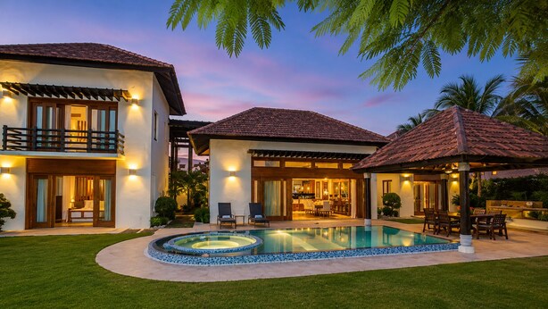 A two-story house with a swimming pool, outdoor seating, and a well-lit patio area. - Villa CapCana: 5-Bedroom Villa with Pool, Jacuzzi, Beach, and Golf (Punta Cana)