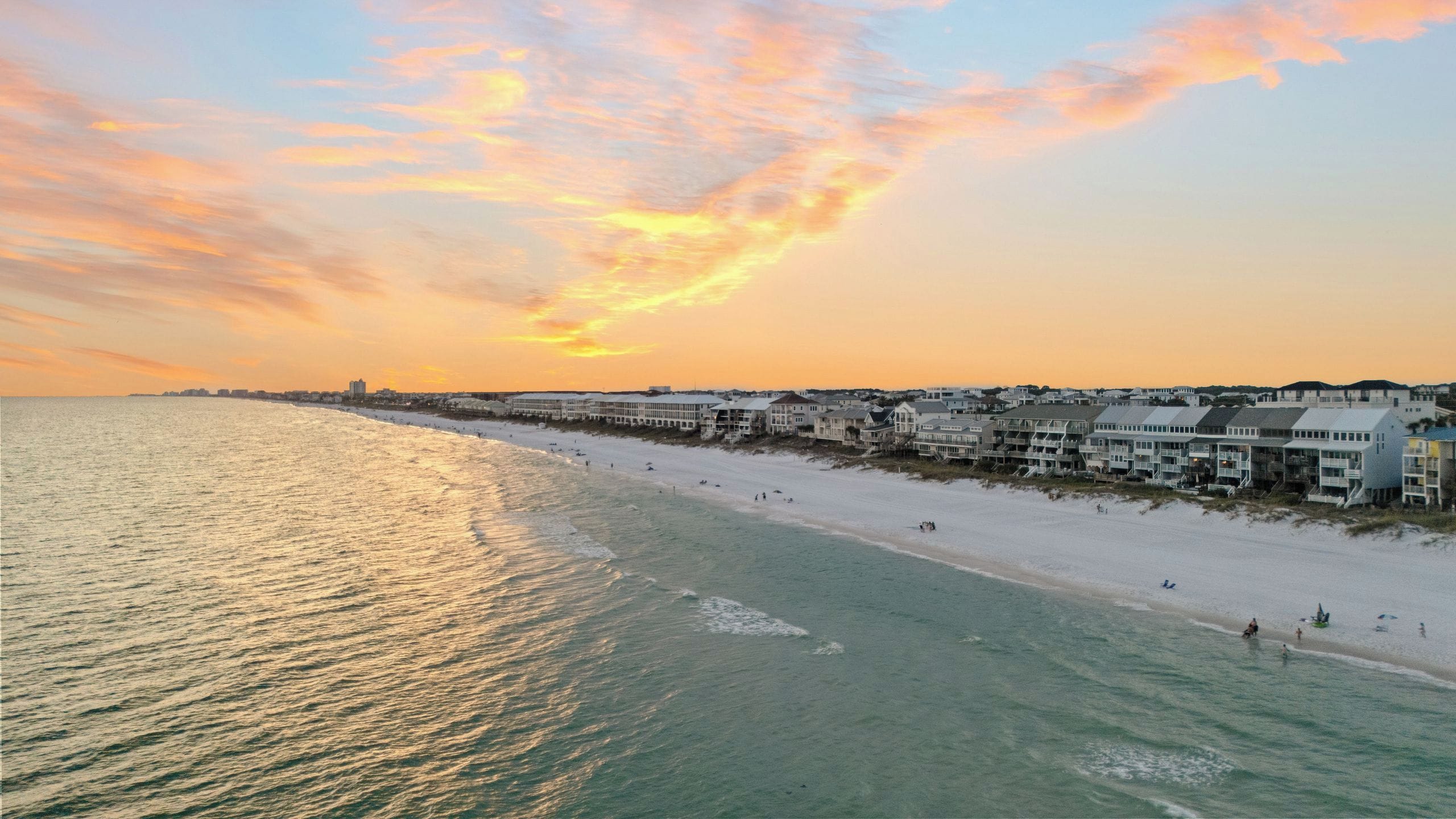 A coastal beach scene with a row of beachfront houses.