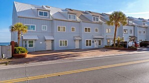 A multi-story hotel with a flat roof, multiple windows, and a paved driveway. - Seawinds 1 by Avantstay Beachfront + Private Beach + Daily Chair Service + 3 Decks (Miramar Beach)