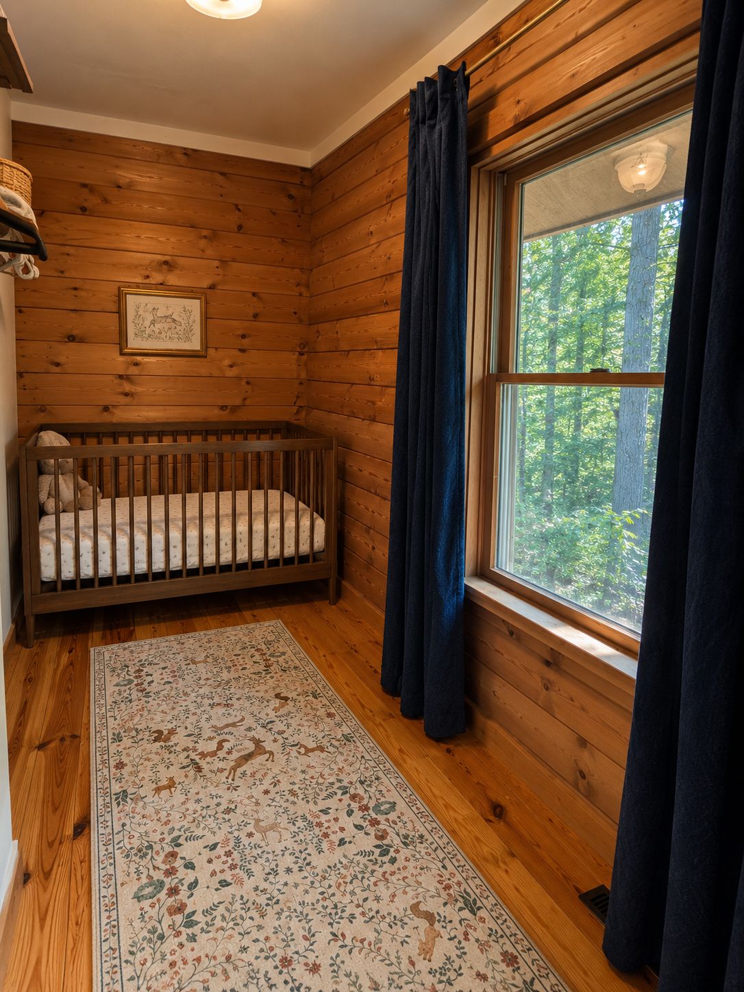 Una habitación de madera con una cuna, un ventanal con cortinas y un cuadro en la pared.