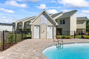 A residential building with a swimming pool, a sign indicating no diving, and a gated entrance. - Townhome with Shared Pool, Wifi & Full Kitchen (Navarre)