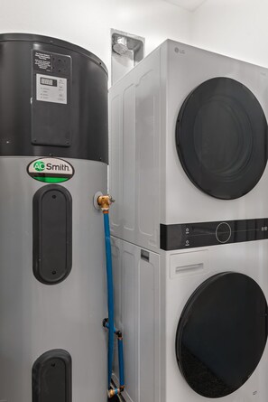 A water heater with a control panel and a washing machine with a circular drum. - Townhome with Shared Pool, Wifi & Full Kitchen (Navarre)