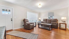 Ein Wohnzimmer mit einer Couch, zwei Sesseln, einem Couchtisch und einem Teppich.