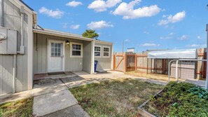 A residential property with a detached garage, a covered patio, and a fenced garden area. - Port Orford Coastal Retreat, Pet Friendly & Fire Pit (Port Orford)