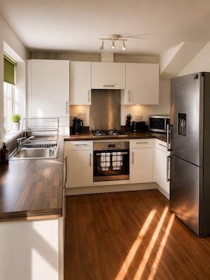 Una cocina moderna con electrodomésticos de acero inoxidable, horno empotrado y microondas.