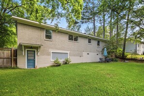 A two-story house with a front door, garage, and a small front yard with grass and a tree. - Spacious 4-bedroom house in beautiful Hot Springs near Oaklawn (Hot Springs)
