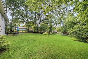 A well-maintained grassy yard with a patio area, surrounded by trees and a building. - Spacious 4-bedroom house in beautiful Hot Springs near Oaklawn (Hot Springs)