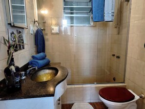 A bathroom with a shower, a sink, and a toilet. - Bright 2BR Apt with Garage Near Ipanema & Copacabana (Rio de Janeiro)