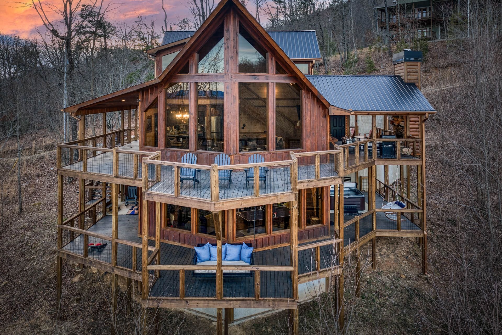 A multi-level wooden cabin with a balcony and outdoor seating area.