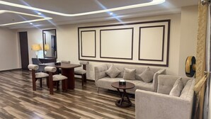 Una sala de estar moderna con un sofá, sillas, una mesa de centro y un comedor con una mesa y sillas.
