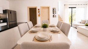 Una zona de dinar moderna amb una taula llarga per a sis persones, envoltada de caires.