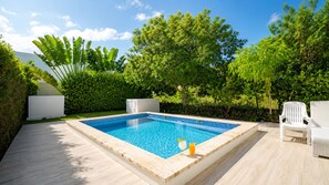 Una piscina rectangular amb vora de rajola, envoltada per un pont de fusta.