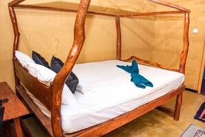 Una cama con dosel de madera con un colchón y almohadas.