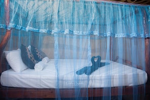 A bed with a mosquito net, pillows, and a heart-shaped decoration. - relax nature villa  (Sigiriya)