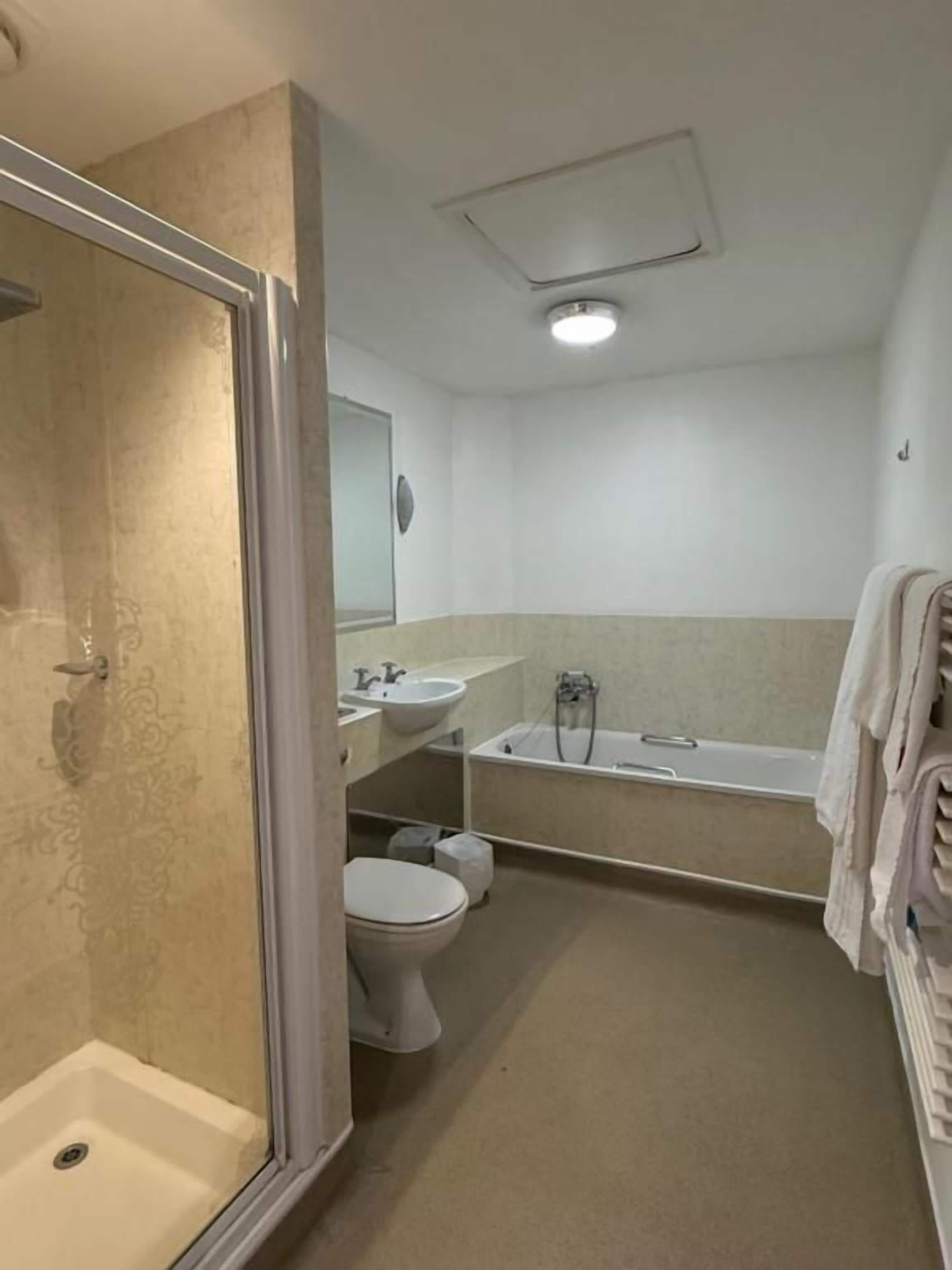 Ein Badezimmer mit Dusche, Toilette, Waschbecken und Badewanne.