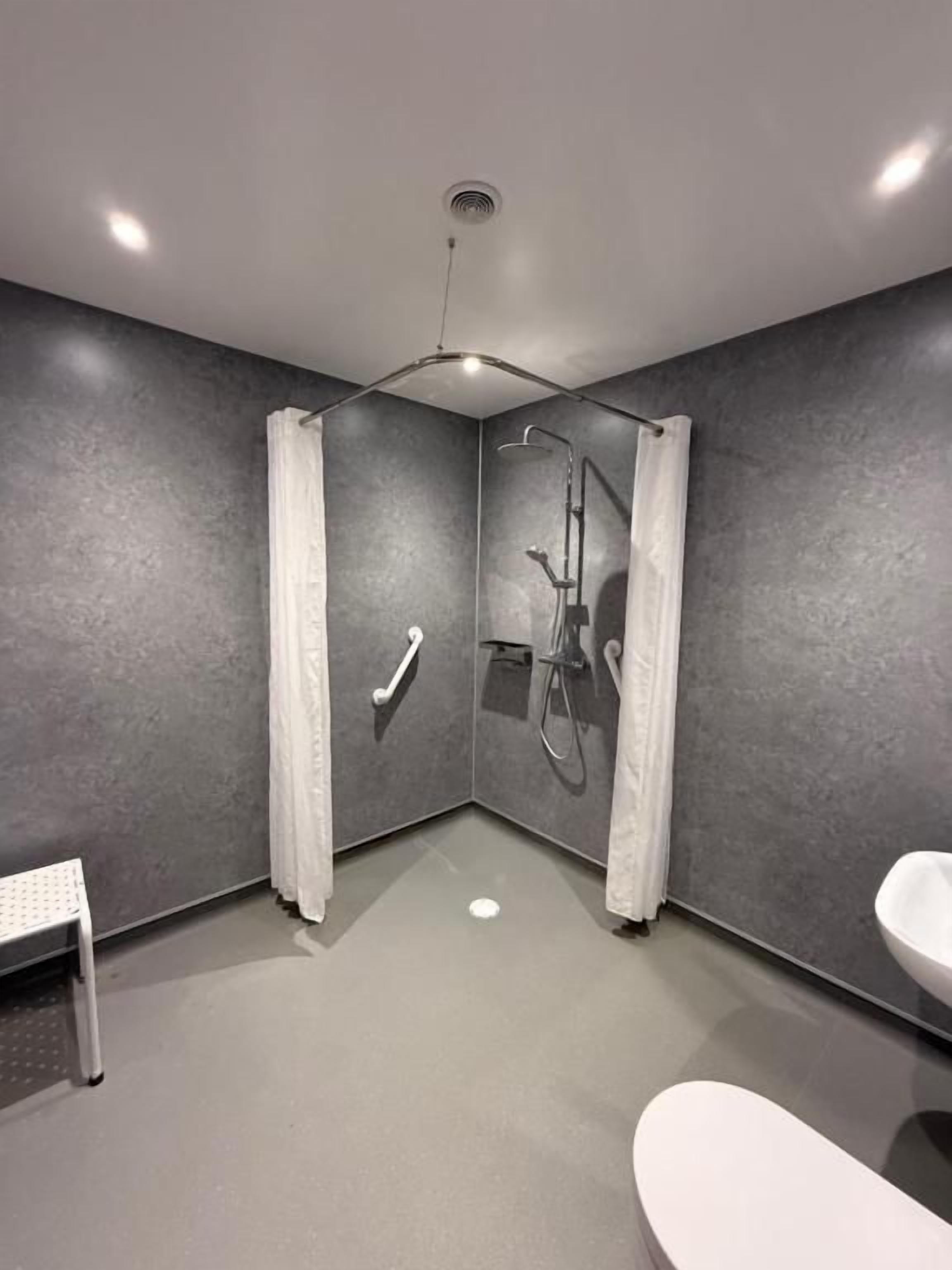 A modern bathroom with a shower, toilet, and bathtub.