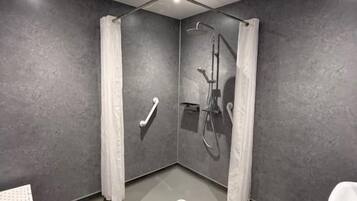 A modern bathroom with a shower, toilet, and bathtub.