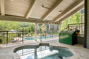A covered outdoor swimming pool area with a hot tub, lounge chairs, and a view of the surrounding landscape. - Snowmass Retreat: Vaulted Ceilings, Wood FP, Balcony W/ Grill & Great Views, W/D, Parking, Pool & HT (Snowmass Village)