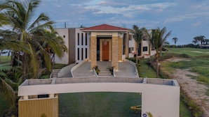 A modern house with a central entrance, surrounded by palm trees and a well-maintained lawn. - Aurea Vita (Tres Vidas Acapulco Diamante)