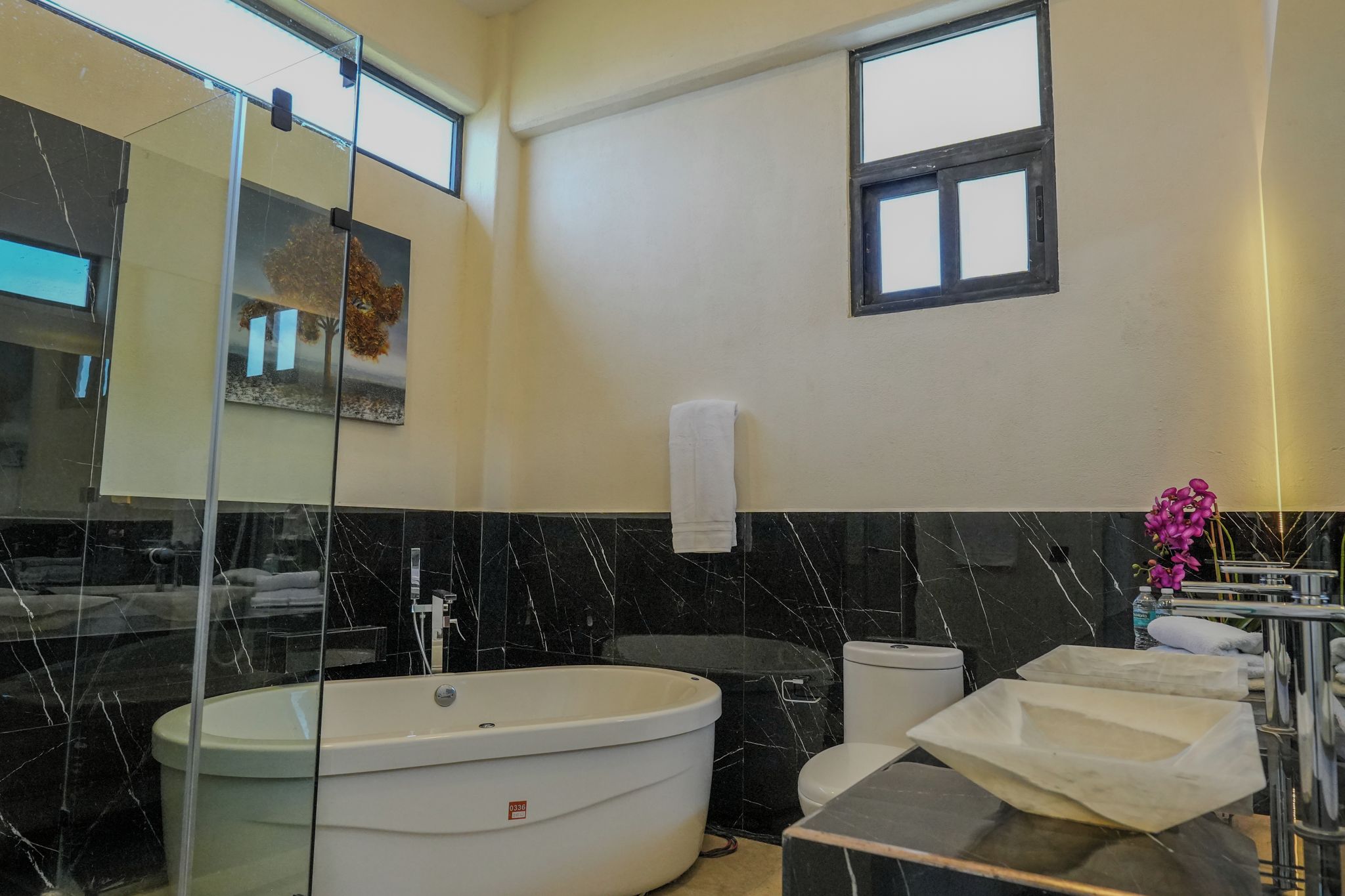 Une salle de bain moderne avec une baignoire sur pieds, des toilettes et un meuble-lavabo avec un miroir.