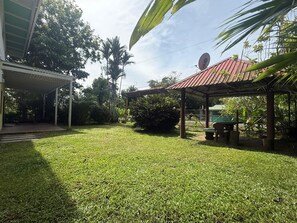 A well-maintained grassy yard with a covered seating area and a satellite dish. - Casa Melda | Walk to the Beach & GandocaManzanillo (Manzanillo)