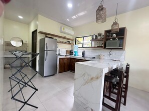 A modern kitchen with a refrigerator, microwave, and wooden cabinets. - Casa Melda | Walk to the Beach & GandocaManzanillo (Manzanillo)
