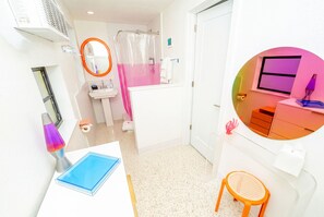 Une salle de bain équipée d’une douche, de toilettes, d’un lavabo et d’un miroir.