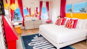 A modern bedroom with a bed, a hanging chair, a dresser, and a mirror.