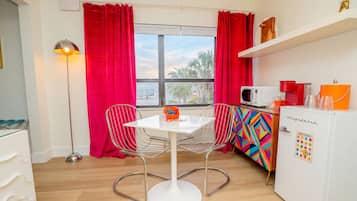 A compact kitchen with a white refrigerator, a microwave, and a colorful cabinet.