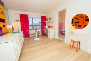 Una cocina moderna con comedor, un refrigerador blanco y una ventana con cortinas.