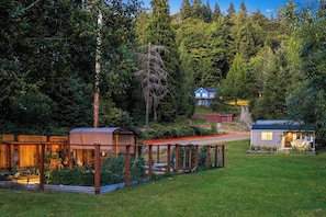 A residential property with a covered outdoor area, a small house, and a pathway leading to a larger building.