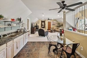 A spacious kitchen with a dining area, a ceiling fan, and a view of the outdoors.