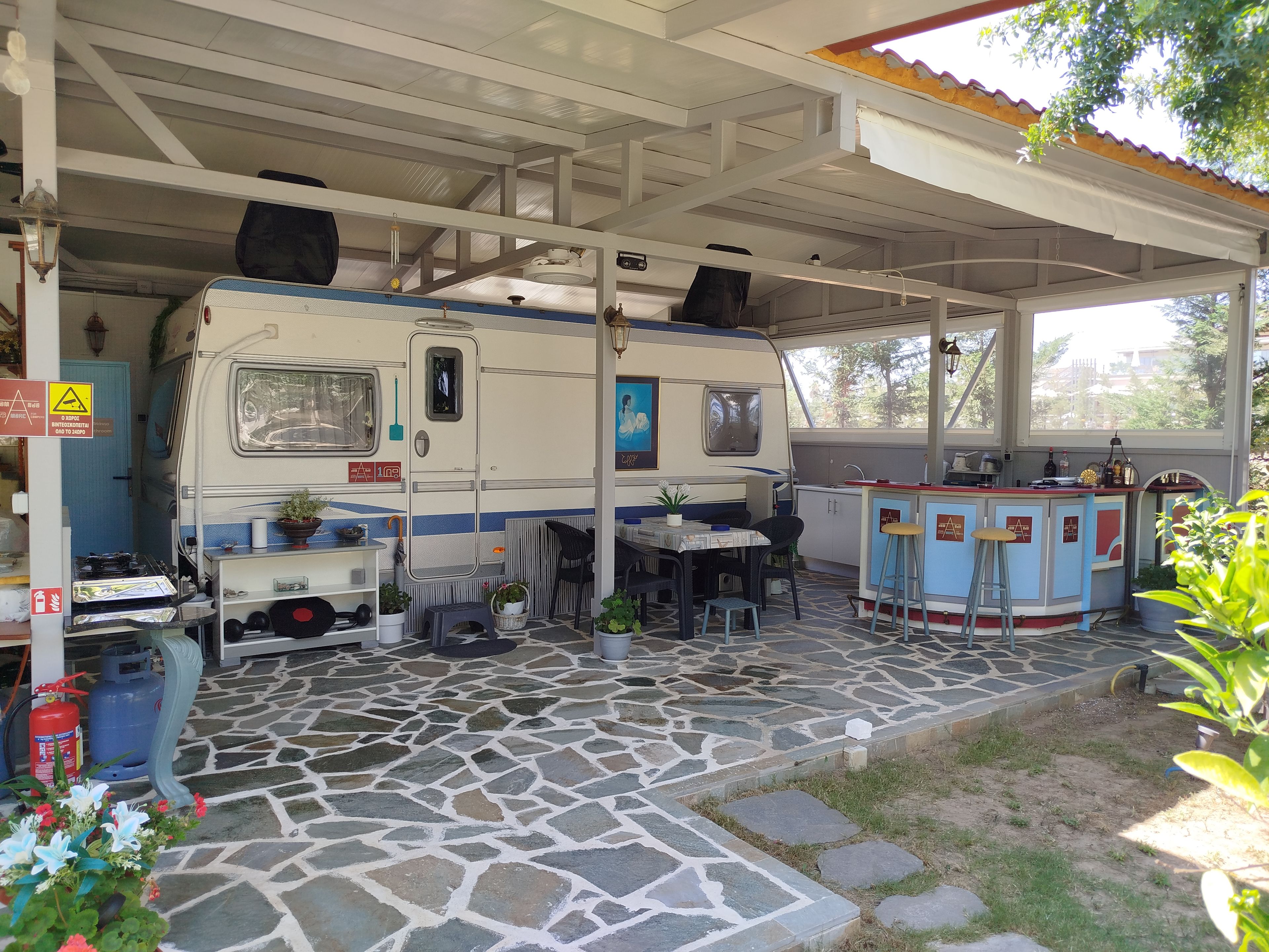 Un espace de stationnement pour camping-cars, abrité et doté d’un coin repas, d’une petite cuisine et de toilettes.