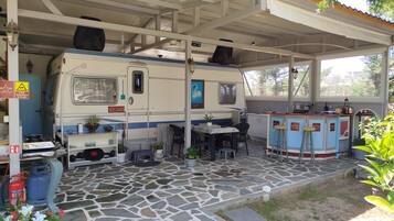 Un espace de stationnement pour camping-cars, abrité et doté d’un coin repas, d’une petite cuisine et de toilettes.