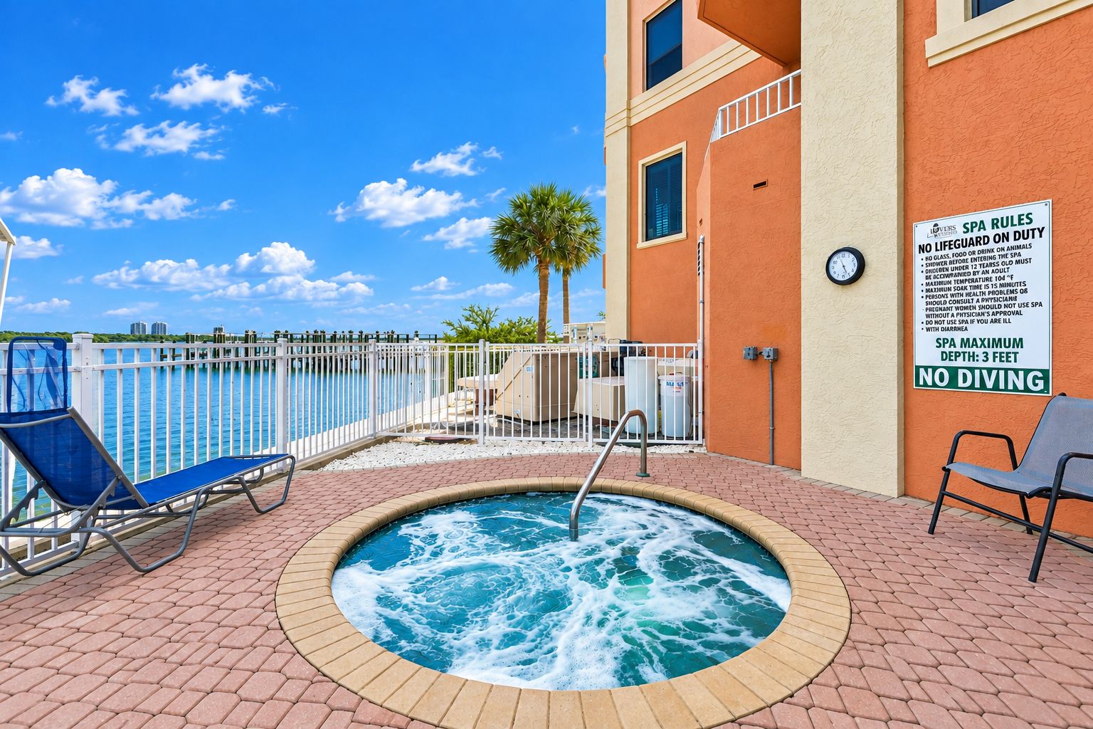 Ein Whirlpool mit Blick auf den Pool, ein Schild mit Spa-Regeln und eine Uhr an der Wand.