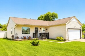 A single-story house with a front porch, a garage, and a well-maintained lawn.