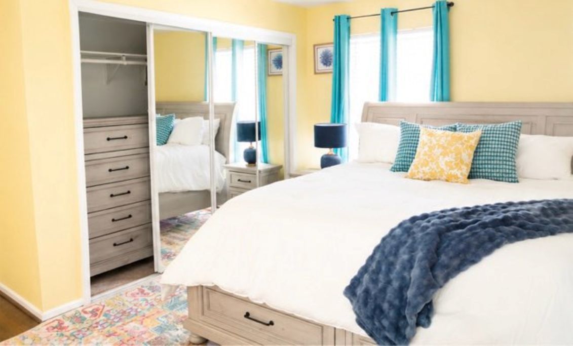 A bedroom with a bed, bedside tables, a wardrobe, and a mirror.