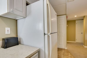 A kitchen with a white refrigerator, a black toaster, and a white countertop.