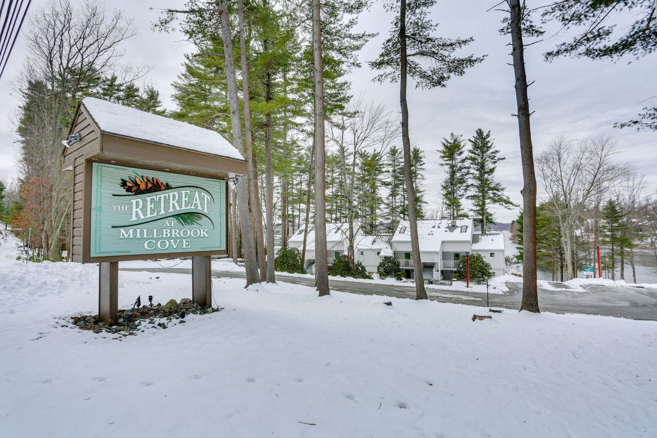 Une enseigne indiquant l'emplacement de « The Retreat at Millbrook Cove », avec un paysage enneigé et des arbres en arrière-plan.