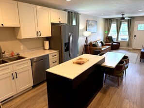 A modern kitchen with a central island, built-in appliances, and a dining area with a table and chairs. - Quiet 2BR Directly Across From Morristown-Hamblen Hospital (Morristown)