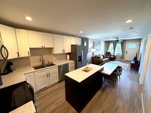 A modern kitchen with a central island, built-in appliances, and a dining area with a table and chairs. - Quiet 2BR Directly Across From Morristown-Hamblen Hospital (Morristown)
