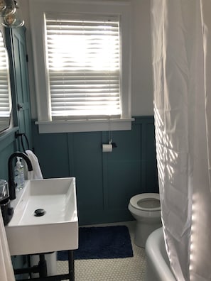 A bathroom with a white sink, a toilet, a window with blinds, and a shower curtain. - Charming 3-bedroom house with AC near the Mishawaka River Front (Mishawaka)